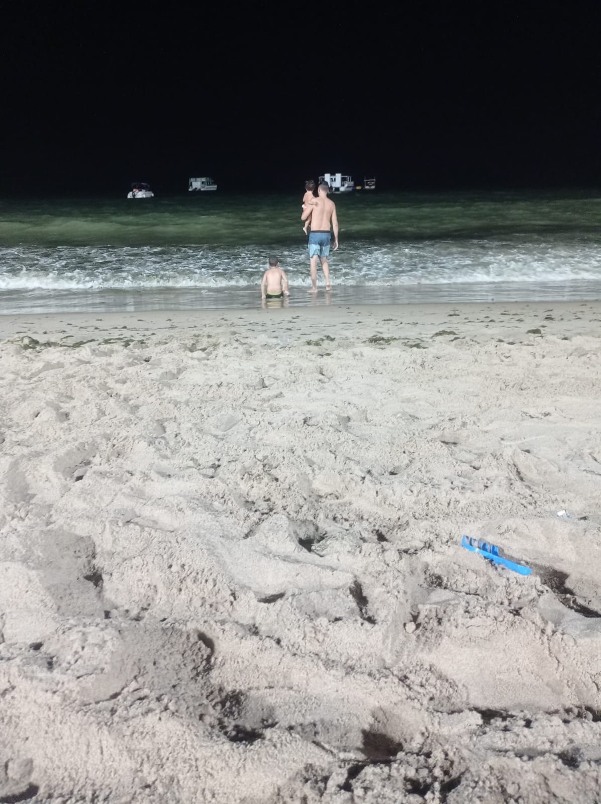 Família na praia à noite