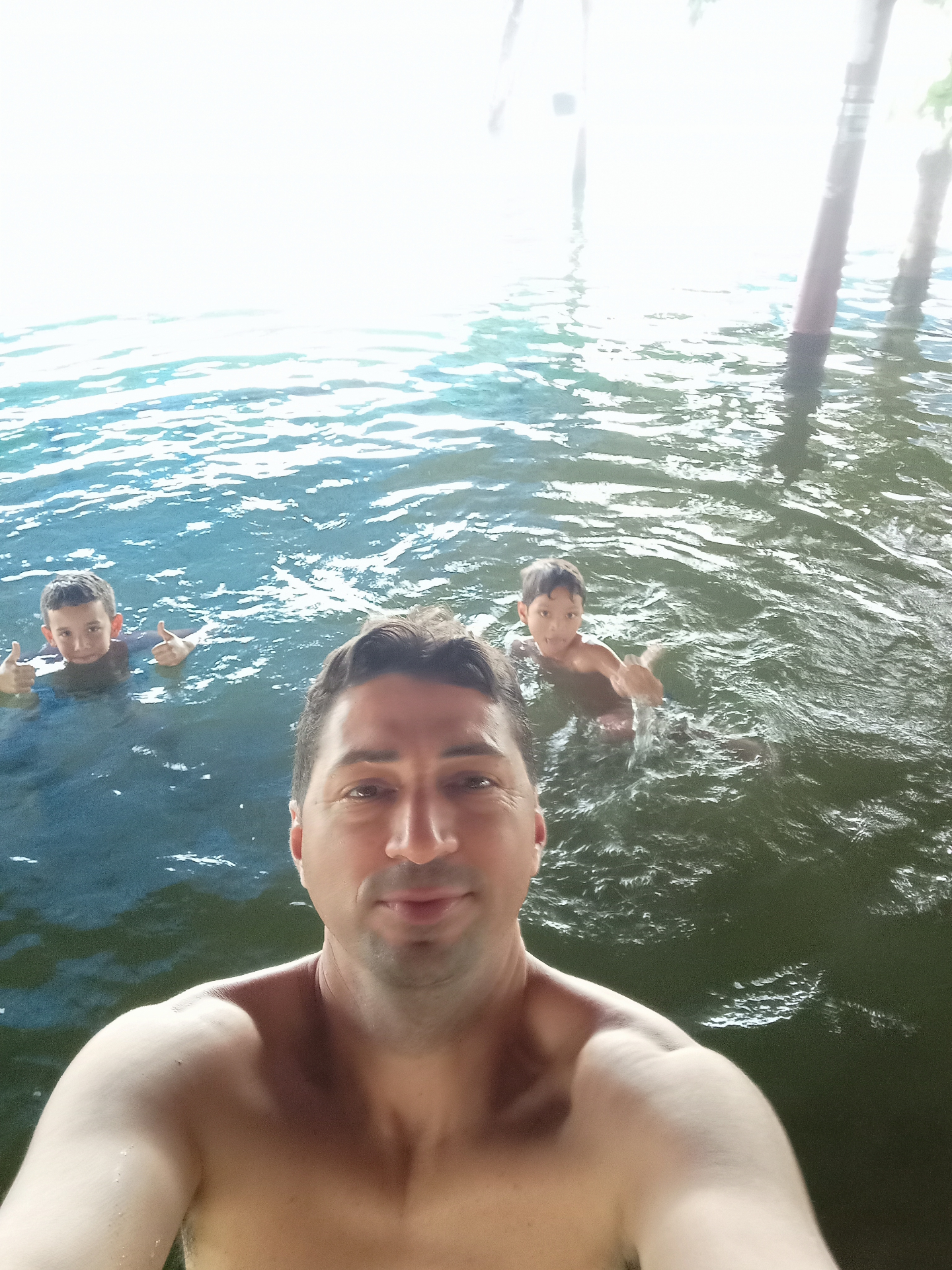 Diego na piscina com filhos